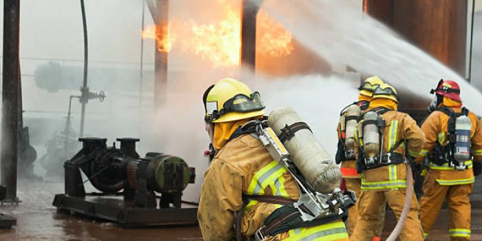 Selective focus is on the firefighter in the foreground.